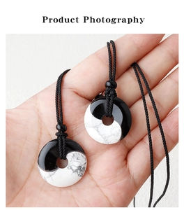 Macro detail of Yin Yang necklaces made of obsidian and turquoise stones on braided cord