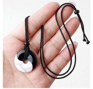 Close-up of Yin Yang pendant necklace with natural obsidian and turquoise stones