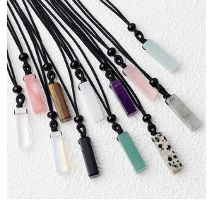 Macro shot of assorted natural gemstone rectangular pendants with braided black cords