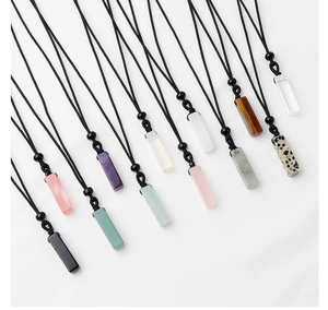 Diagonal arrangement of eleven colorful rectangular natural stone pendants with black cords