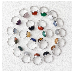 Detailed top view of twenty assorted natural crystal and agate stones on adjustable rings
