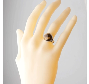 Detailed view of a 15mm round amber stone ring set on a silver stainless steel band