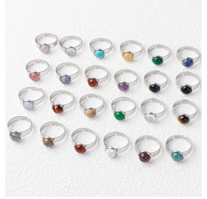 Detailed macro view of multiple round 11mm natural stone rings in silver adjustable bands