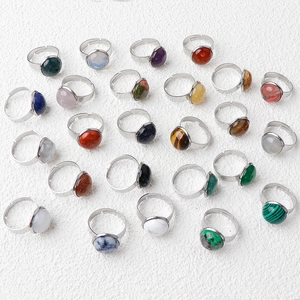 Multiple natural crystal stone rings with adjustable stainless steel bands on white background