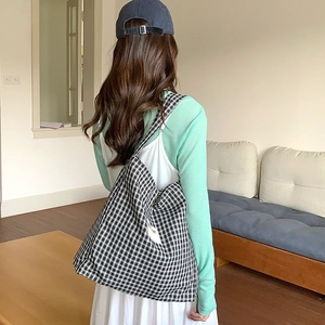 Black and white gingham tote bag showing its size and drape on a model's shoulder