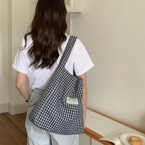 Minimalist black and white checkered canvas tote bag for women shown on model