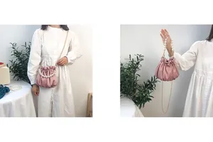 Detail of pink pleated cloud bag featuring large pearl handle and golden chain strap