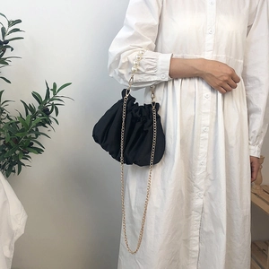 Elegant black cloud pleat handbag with large pearl handle and gold chain strap