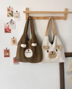 Detail of faux lamb wool shoulder bags with cute bear ears and embroidery on wood hangers