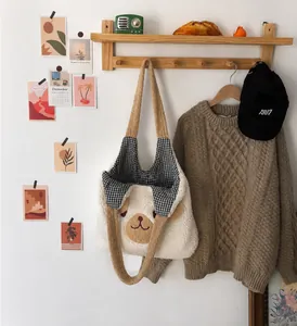 Close-up of white plush bear tote bag with brown details and magnetic closure detail