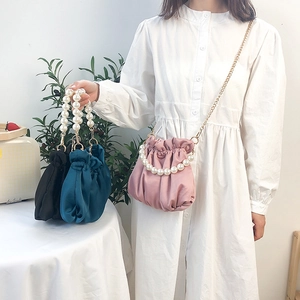 Elegant satin cloud bags with pearl handles and chain straps in black, green, and pink