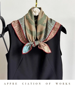 Silk wool scarf with fish scale pattern tied as a bow on a black sleeveless top
