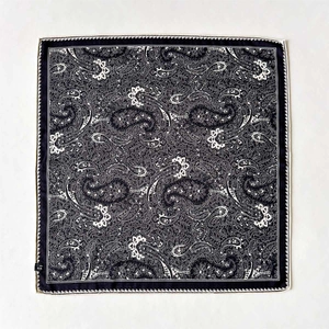 Classic black and white paisley print silk wool blend square scarf flat lay on beige background