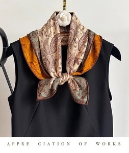 Detail of paisley silk scarf styled with camellia flower on black sleeveless top