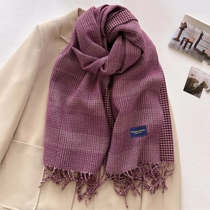 Close-up of deep purple houndstooth scarf with elegant fringes and branded label detail