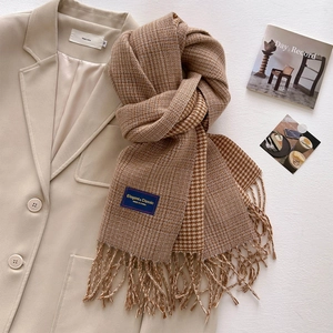 Close-up of retro houndstooth scarf with elegant label and fringe detailing