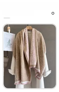 Détail du motif jacquard floral sur une écharpe douce en imitation cachemire beige et rose