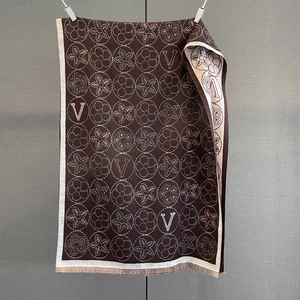 Détail d'une écharpe de luxe en jacquard floral marron et beige avec franges élégantes