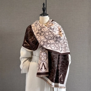 Détail d'un châle d'hiver épais montrant la texture jacquard et les fines franges