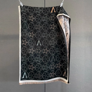 Vue détaillée du motif jacquard floral noir et des franges fines sur l'écharpe