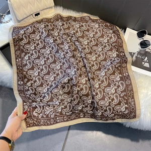 Flat lay of retro paisley print square scarf on white faux fur with accessories