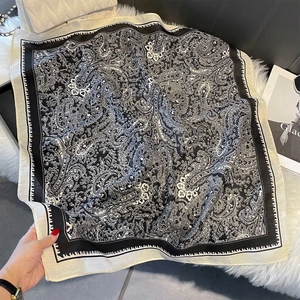 Detail of vintage paisley print square scarf with elegant black border and silk feel
