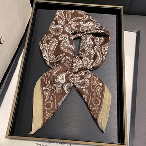 Brown paisley print square scarf with beige border on a minimalist black display tray