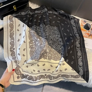 Détail macro du foulard carré à motif paisley en soie avec des motifs en diagonale