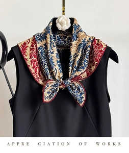 Detail of a vintage floral silk scarf tied in a bow on a black sleeveless top