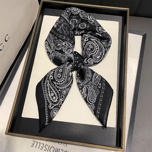 Carré de soie 68cm imprimé paisley noir et blanc noué en nœud sur un présentoir