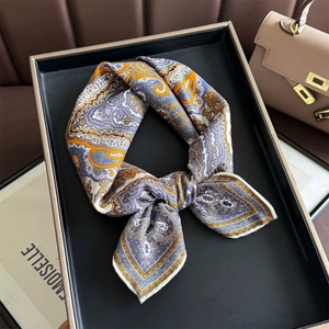 Elegant silk wool blend square scarf with paisley print displayed on a black tray