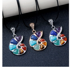 Détail macro des pendentifs en forme de conque avec sept cristaux de chakra naturels