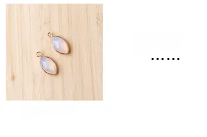 Detail showing two marquise cut opalite stones with golden copper edges on wood