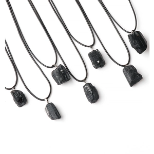 Macro detail of raw black tourmaline crystal pendants with natural mineral texture