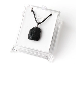 Macro shot of irregular natural black tourmaline stone pendant with silver clasp in a gift box