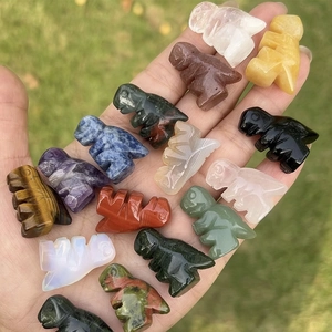 Set of 1-inch natural crystal dinosaur carvings in various gemstones held in hand