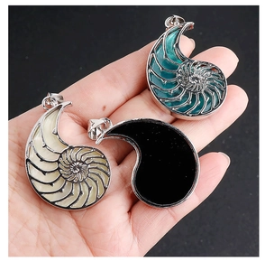 Detailed view of spiral seashell pendants in white green and black on a silver frame