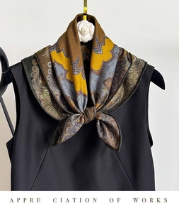 Detail of vintage paisley silk blend square scarf styled on a black top neckline