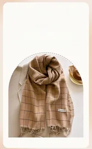Detail of camel plaid scarf with soft fringe edges and premium cashmere-like texture
