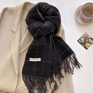 Detail of plaid scarf texture with tassels on wool coat in a warm aesthetic setting