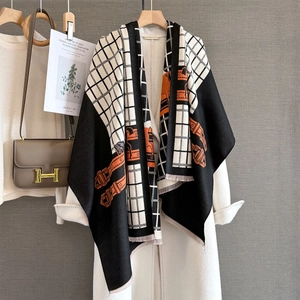 Écharpe à carreaux jacquard avec motifs équestres et franges sur un manteau blanc