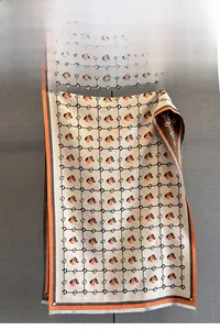 Detail of horse pattern jacquard scarf with orange edges and fringe tassels
