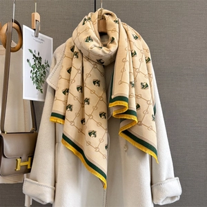 Close-up of cashmere-feel scarf with horse head pattern and detailed fringe tassels