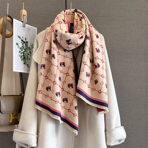 Detail of horse head jacquard scarf texture with fringe on beige cashmere-like fabric