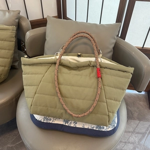 Olive green quilted tote bag with orange woven rope handles for spring commuting