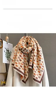 Close-up of beige imitation cashmere scarf with orange calf prints and fringe edges