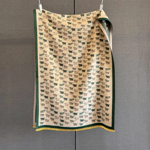 Detailed close-up of a cozy knitted scarf with cute cartoon cow motifs and yellow tassels