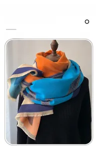 Detail of color-block scarf featuring orange and blue fringe on imitation cashmere fabric