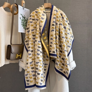 Detail of the woven fabric texture and cute yellow cow pattern on a beige autumn scarf