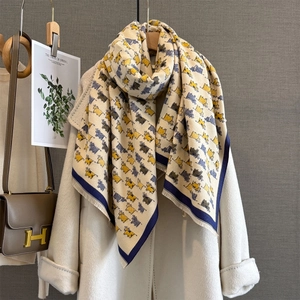 Close-up of the thick knitted fabric and cute animal pattern on the autumn scarf